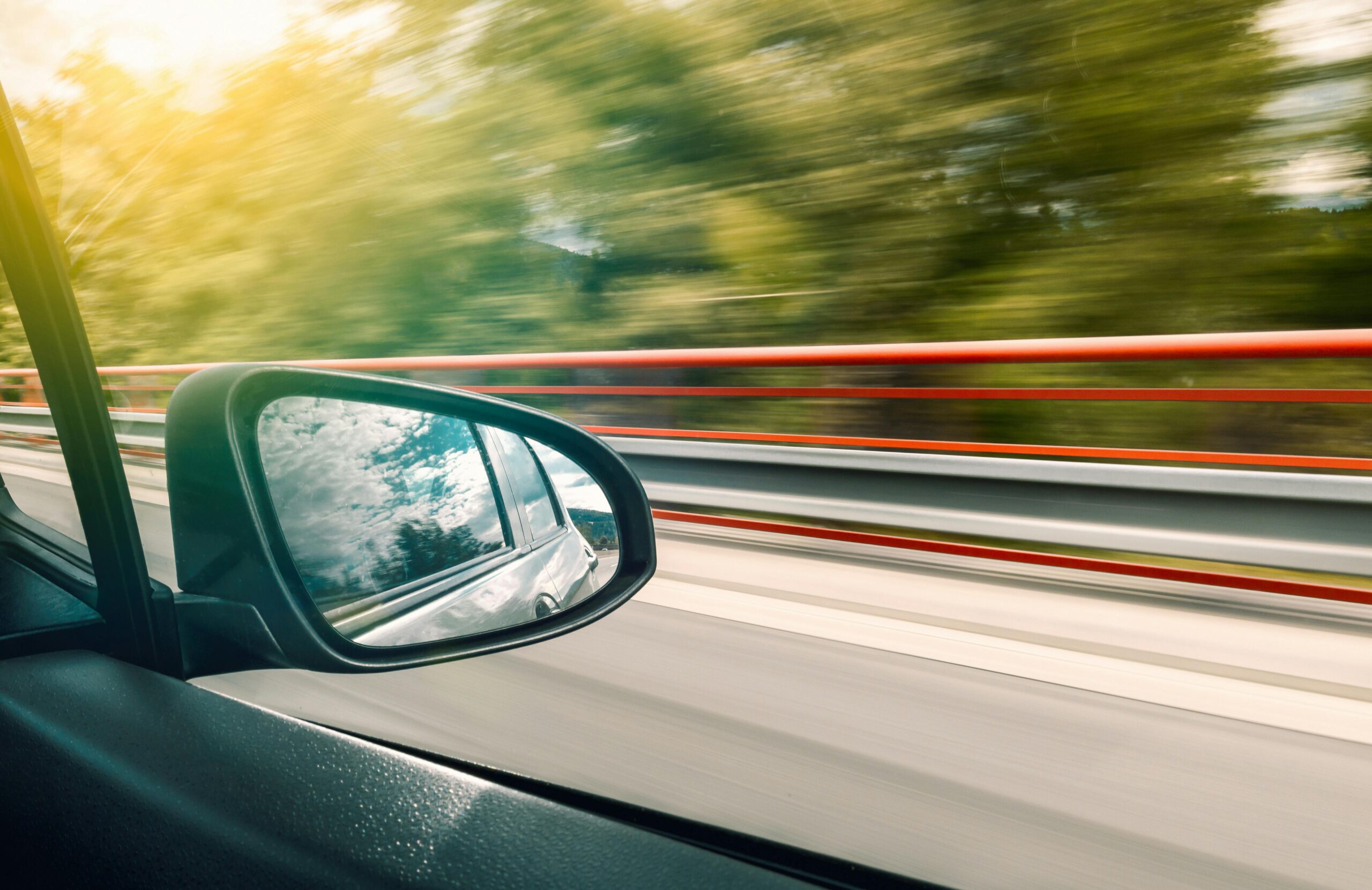Picture of a car mirror while it is driving down the road